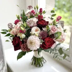 Blush & Burgundy wedding bouquet by a window