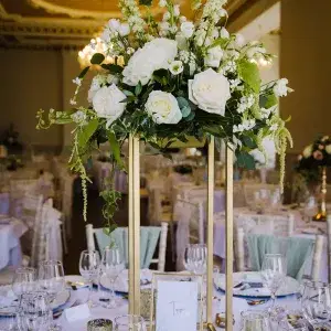 Wedding table with tall white flower wedding arrangement in the middle